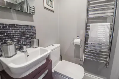 a white bathroom with a sink and a toilet at Holly Lodge in Aldeburgh
