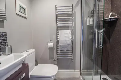 a bathroom with a shower and a toilet and a sink at Holly Lodge in Aldeburgh