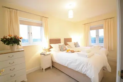 a bedroom with two beds and two windows at Red Robin, Whepstead in Whepstead