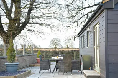a patio with a table and chairs on it at Red Robin, Whepstead in Whepstead