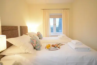 a hotel room with two beds with a tray of food at Red Robin, Whepstead in Whepstead