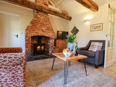 a living room with a brick fireplace and a table at Remus in Larling