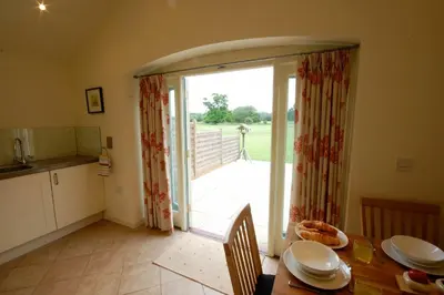 a kitchen and dining room with a table and a sliding glass door at Remus in Larling