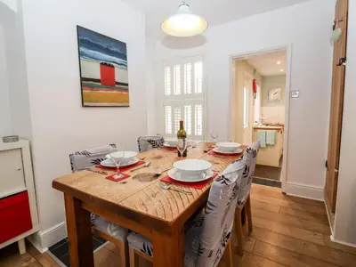 a dining room with a wooden table and chairs at Holmleigh, Aldeburgh in Aldeburgh