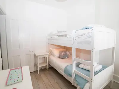 a bedroom with two bunk beds and a desk at Holmleigh, Aldeburgh in Aldeburgh