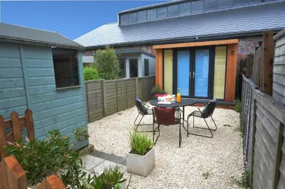 a patio with a table and chairs in a backyard at Holmleigh, Aldeburgh in Aldeburgh