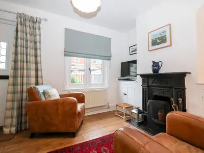 a living room with a couch and a fireplace at Holmleigh, Aldeburgh in Aldeburgh