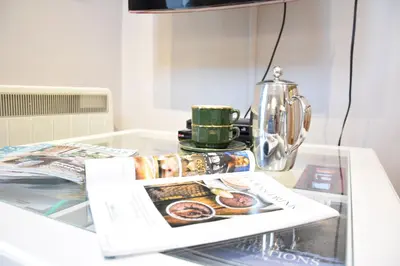 a glass table with a coffee pot and a magazine at Pied a Mer, Aldeburgh in Aldeburgh