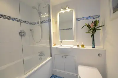 a bathroom with a sink and a shower and a toilet at Pied a Mer, Aldeburgh in Aldeburgh