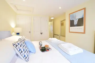 a white bed with a tray of food on it at Pied a Mer, Aldeburgh in Aldeburgh