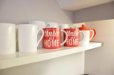 a row of coffee mugs sitting on a shelf at Pied a Mer, Aldeburgh in Aldeburgh