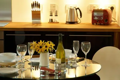 a table with glasses and a bottle of wine on it at Chobbs Barn, Eye in Eye