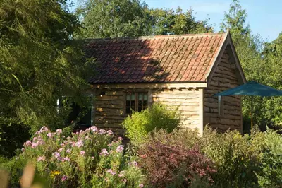 a small house in a garden with flowers at Chobbs Barn, Eye in Eye