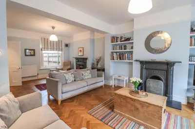 a living room with a couch and a fireplace at Lavender House, Aldeburgh in Aldeburgh