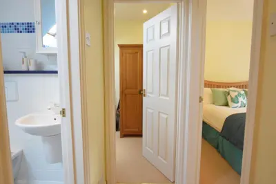 a bathroom with a bed and a sink and a toilet at Seafarers in Fressingfield