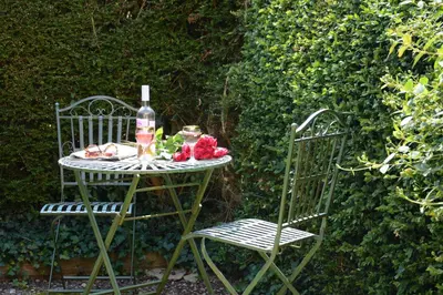a table with a bottle of wine and two chairs at Seafarers in Fressingfield