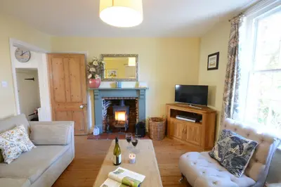 a living room with a couch and a fireplace at Pebble Beach Cottage, Aldeburgh in Aldeburgh