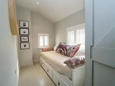 a small bedroom with a bed and a window at Mariners Cottage in Aldeburgh