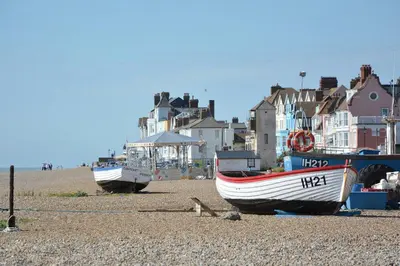 two boats sitting on the shore of a beach at Mariners Cottage in Aldeburgh