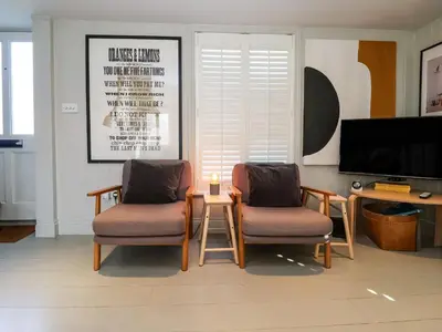 two chairs and a table in a living room with a tv at Mariners Cottage in Aldeburgh