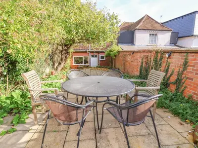 a patio with a table and chairs in a backyard at Lavender Cottage, Aldeburgh in Aldeburgh