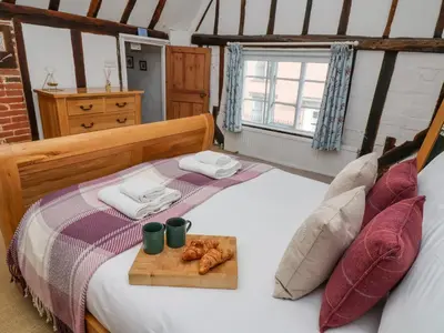 a bedroom with a bed with a tray of donuts on it at Lavender Cottage, Aldeburgh in Aldeburgh