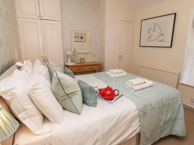 a bedroom with a bed with a tea pot on it at Winkle Cottage, Aldeburgh in Aldeburgh
