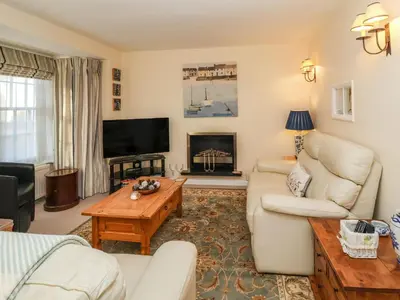 a living room with a couch and a tv at Winkle Cottage, Aldeburgh in Aldeburgh