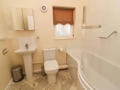 a bathroom with a toilet and a sink and a tub at Winkle Cottage, Aldeburgh in Aldeburgh