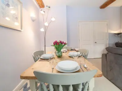 a dining room with a wooden table and chairs at Saffron, Blythview in Blythburgh