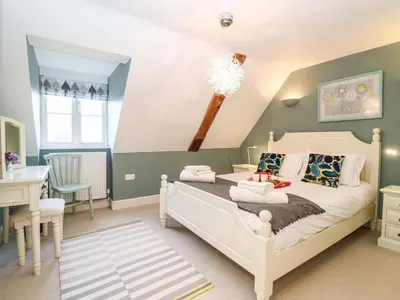 a bedroom with a bed and a desk and a table at Saffron, Blythview in Blythburgh