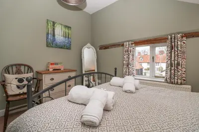 a bedroom with a bed with towels on it at 1 The Old Coach House in Laxfield