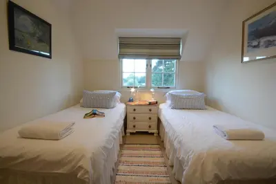 two twin beds in a room with a window at 2 The Bays, Thorpeness in Thorpeness