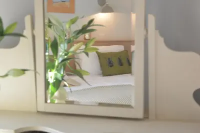 a mirror reflection of a bed in a bedroom at Little Turnpike Cottage, Melton in Woodbridge