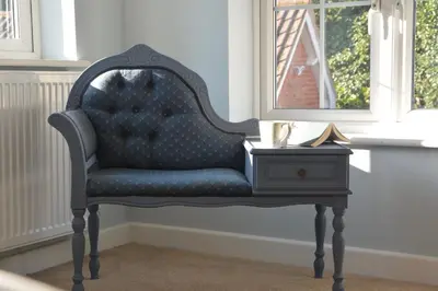 a blue chair sitting next to a side table at Little Turnpike Cottage, Melton in Woodbridge