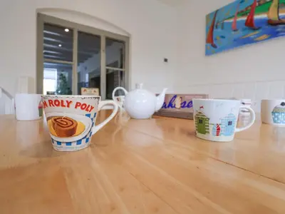 a group of coffee cups sitting on a wooden floor at Pudding Cottage, Westleton in Westleton