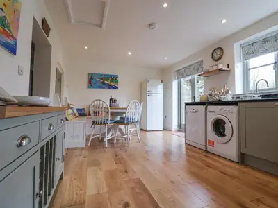 a kitchen with a table and a washing machine at Pudding Cottage, Westleton in Westleton