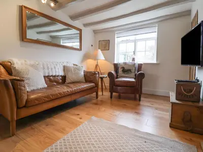 a living room with a couch and a chair at Pudding Cottage, Westleton in Westleton
