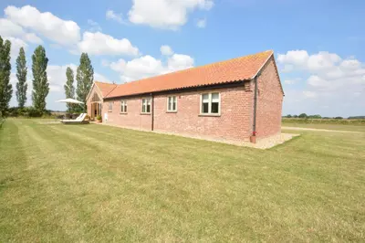 a red brick house with a large grass yard at The Mulberry, nr Bungay in Bungay