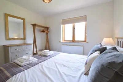 a bedroom with a white bed with two towels on it at The Mulberry, nr Bungay in Bungay