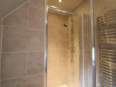 a shower with a glass door in a bathroom at Quill Farm Barn in Campsea Ashe