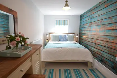 a bedroom with a bed and a wooden wall at Alinka, Aldeburgh in Aldeburgh
