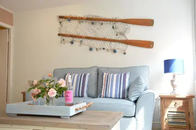 a living room with a blue couch and a table at Alinka, Aldeburgh in Aldeburgh