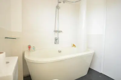 a white bath tub in a bathroom with a shower at Aldeburgh Lodge Gardens in Aldeburgh