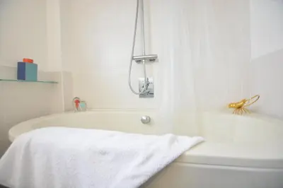 a white bath tub with a white towel on it at Aldeburgh Lodge Gardens in Aldeburgh