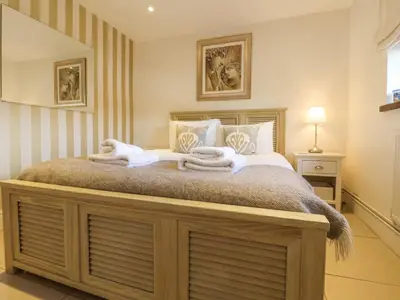 a bedroom with a large bed with towels on it at Little Wissett, Aldeburgh in Aldeburgh