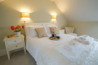 a bedroom with a white bed with towels on it at 10 Church Walk, Aldeburgh in Aldeburgh