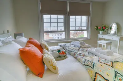a bedroom with two beds with pillows and a table at 10 Church Walk, Aldeburgh in Aldeburgh