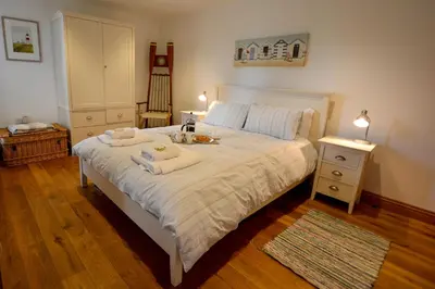 a bedroom with a bed with towels on it at Two Chantry Barns, Orford in Orford