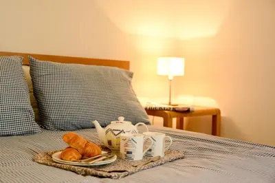a tray of breakfast food on a bed with croissants at Two Chantry Barns, Orford in Orford
